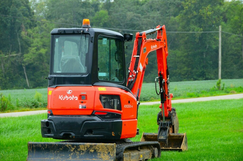 an orange tractor is parked in the grass