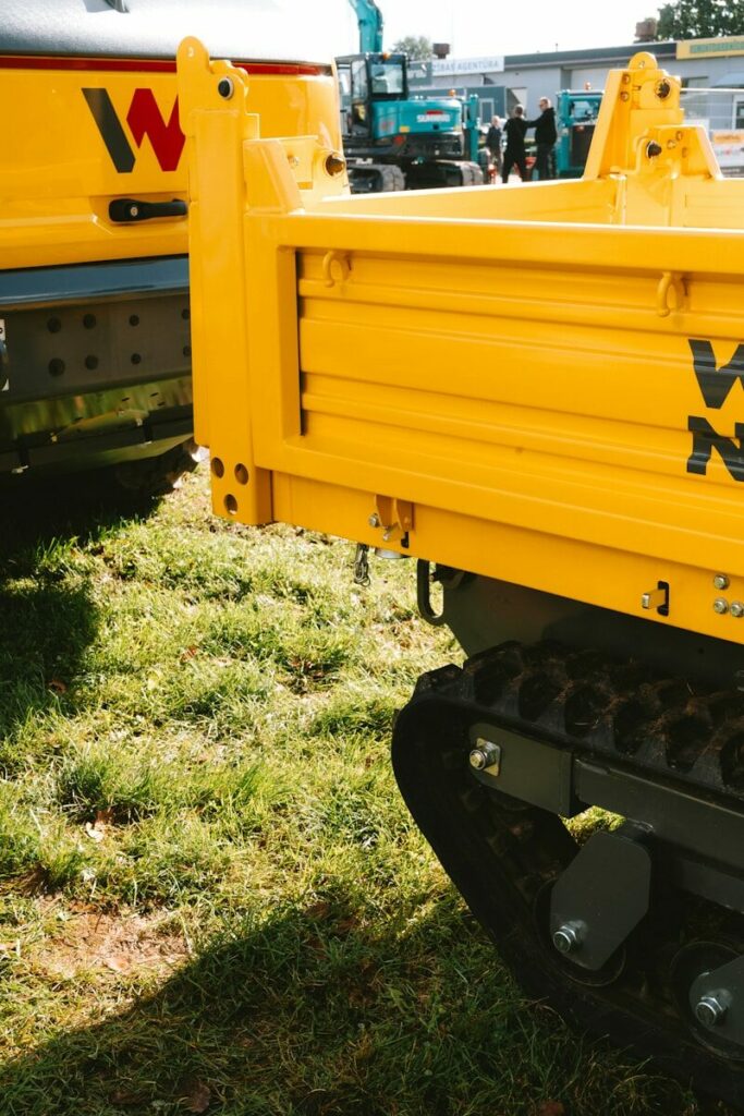 Yellow construction vehicle with tracks on grass